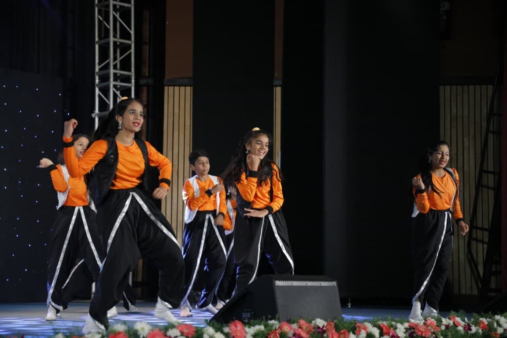 Students performing a group dance on stage at Lawrence High School