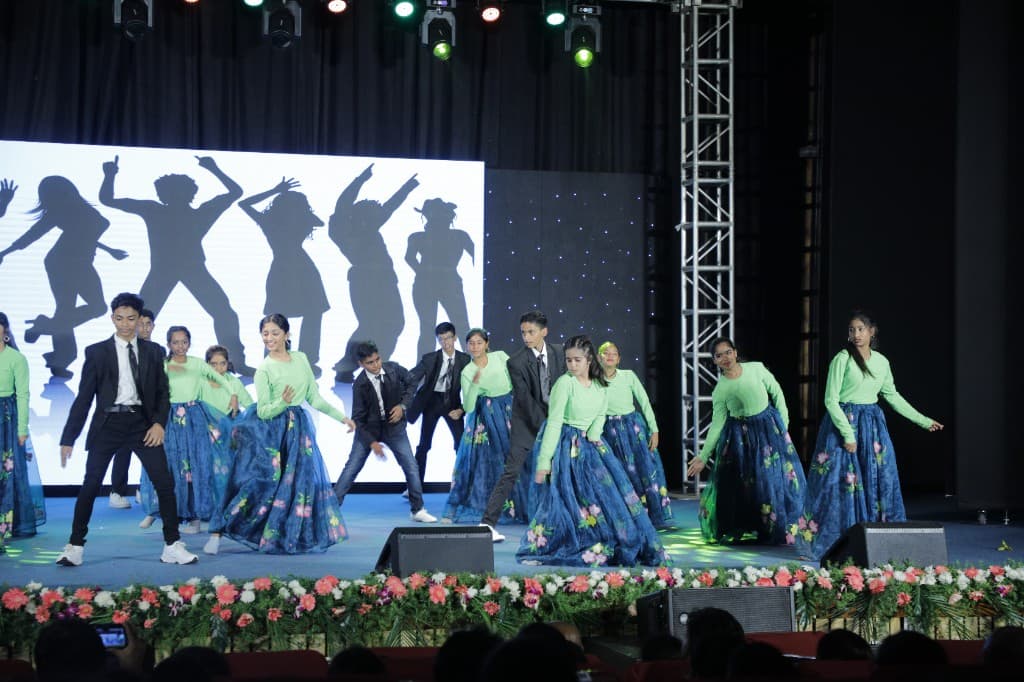 High school students performing a group dance on stage at Lawrence High School