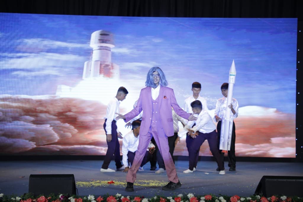 High school students performing a science-themed stage act at Lawrence High School