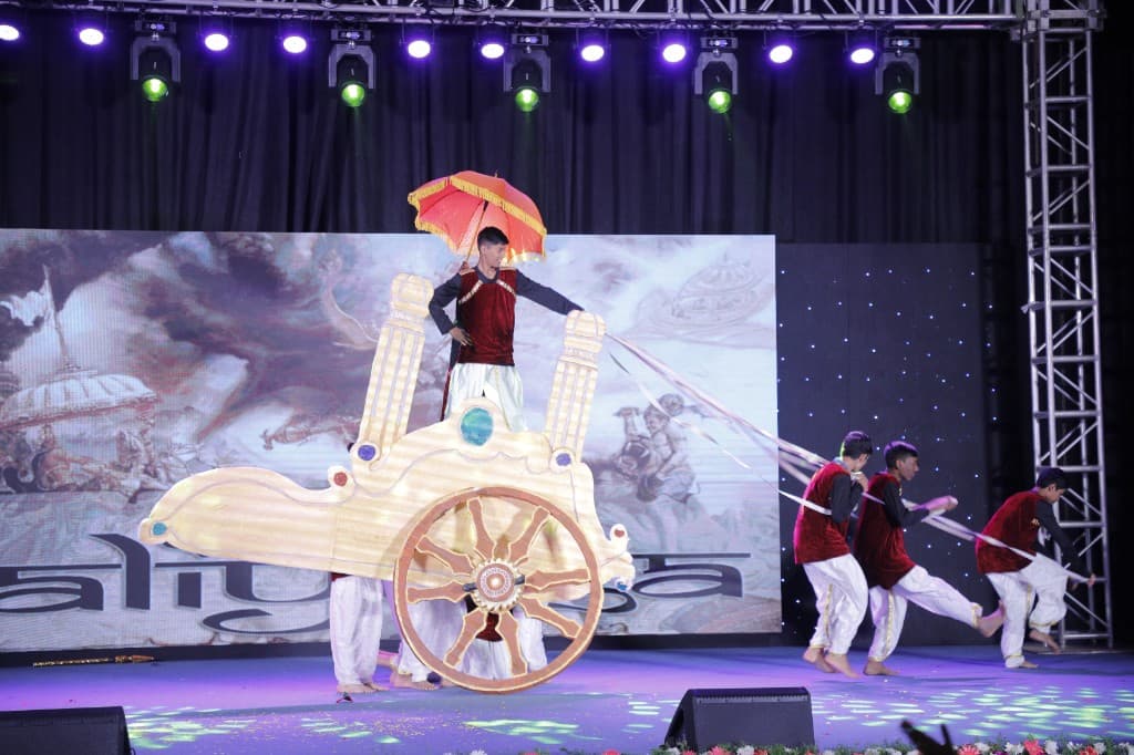 High school students performing with a chariot prop on stage at Lawrence High School