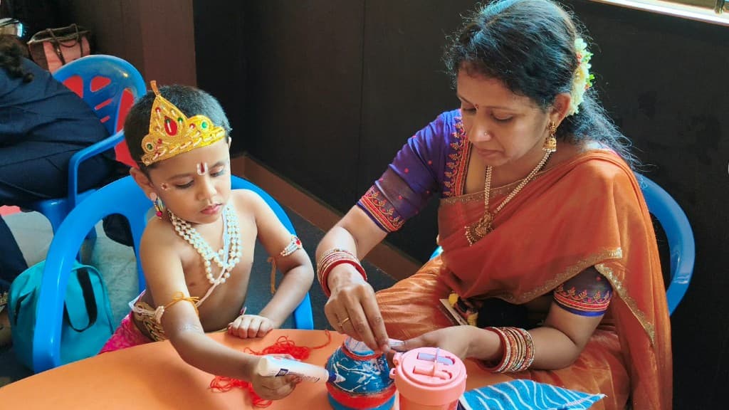 A kindergarten child and parent decorating a pot together at Lawrence High School