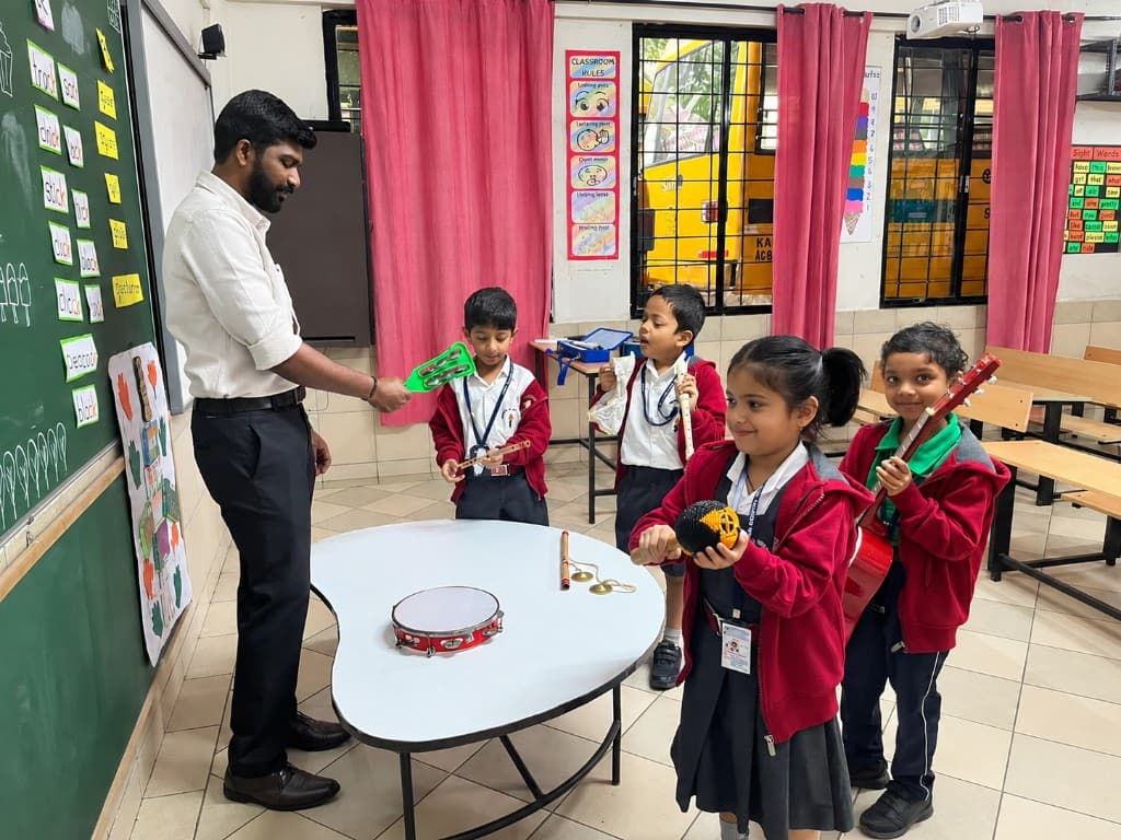 A teacher making music with kindergarten children at Lawrence High School