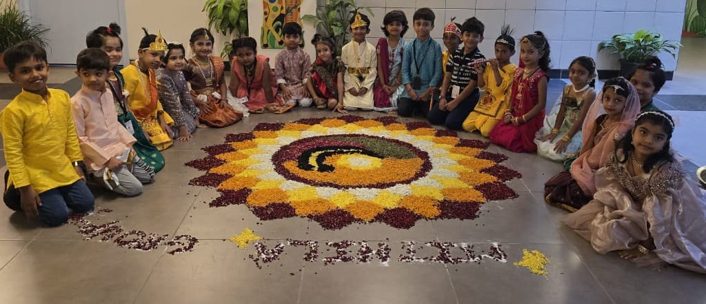Kindergarten children in festive dress around a rangoli at Lawrence High School