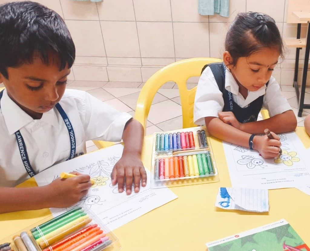 Kindergarten children colouring with crayons at Lawrence High School