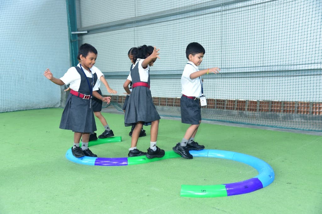 Kindergarten children balancing on a play track at Lawrence High School