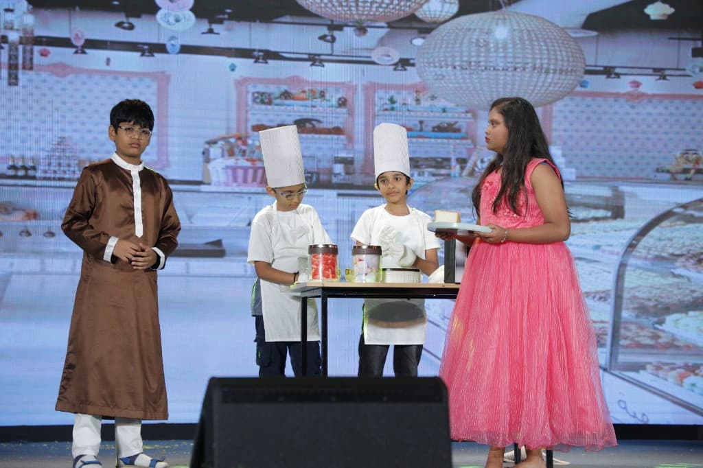 Middle school students performing a bakery scene on stage