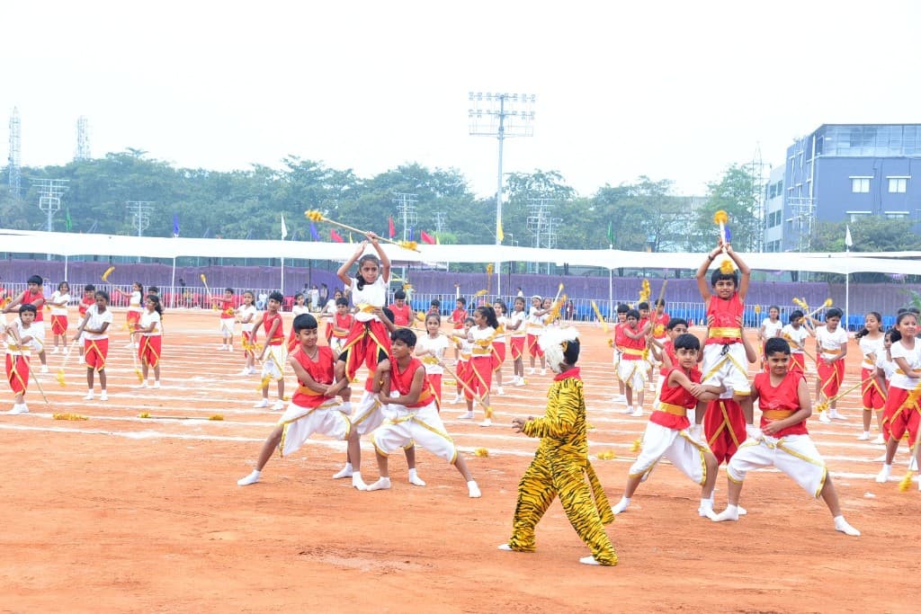 Primary students performing a group dance on the sports ground
