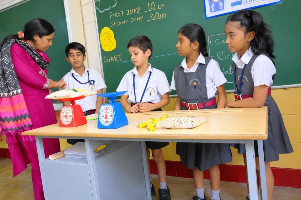 Primary students measuring and weighing in a classroom at Lawrence High School