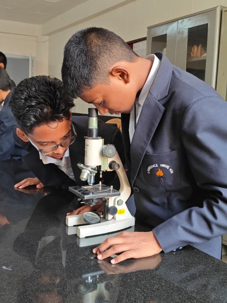 Students using a microscope in the Lawrence High School biology laboratory