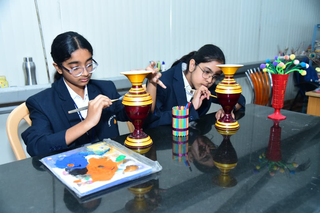 Students painting decorative vases in art class at Lawrence High School
